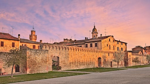 A historic stone building with arched walkways and a tower.