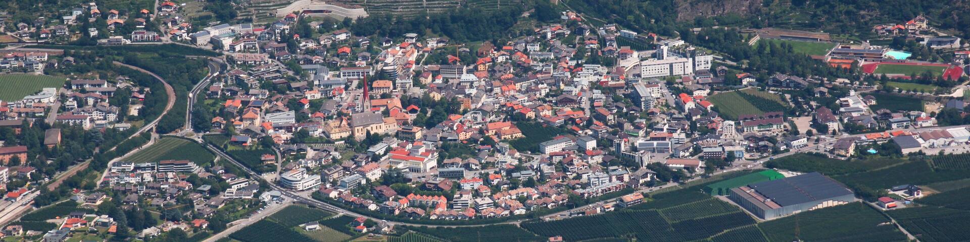 Panoramic view of Schlanders village and apple orchards in the Vinschgau valley, South Tyrol in Italy
