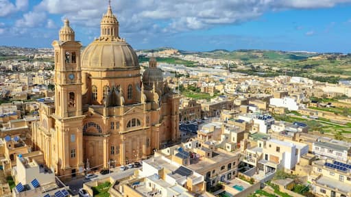 Aerial view oа St. John Baptist Church. Countryside of Gozo island, cloudy blue sky. Europe. Malta country