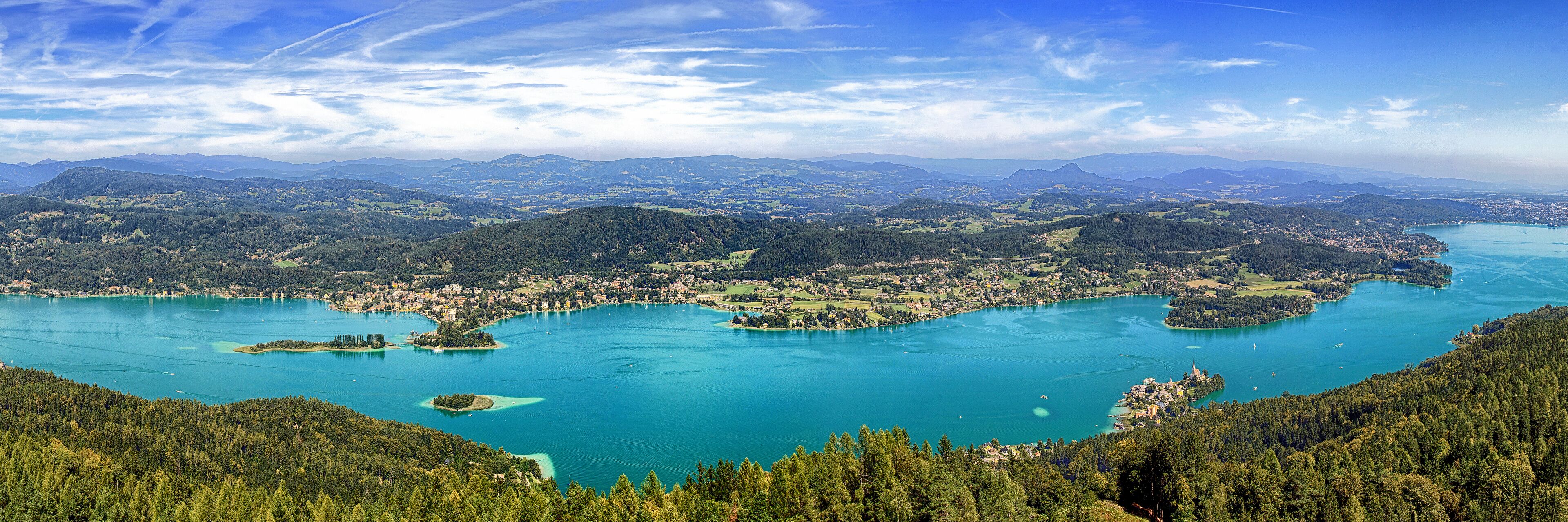 A lake surrounded by forested hills and a small town.