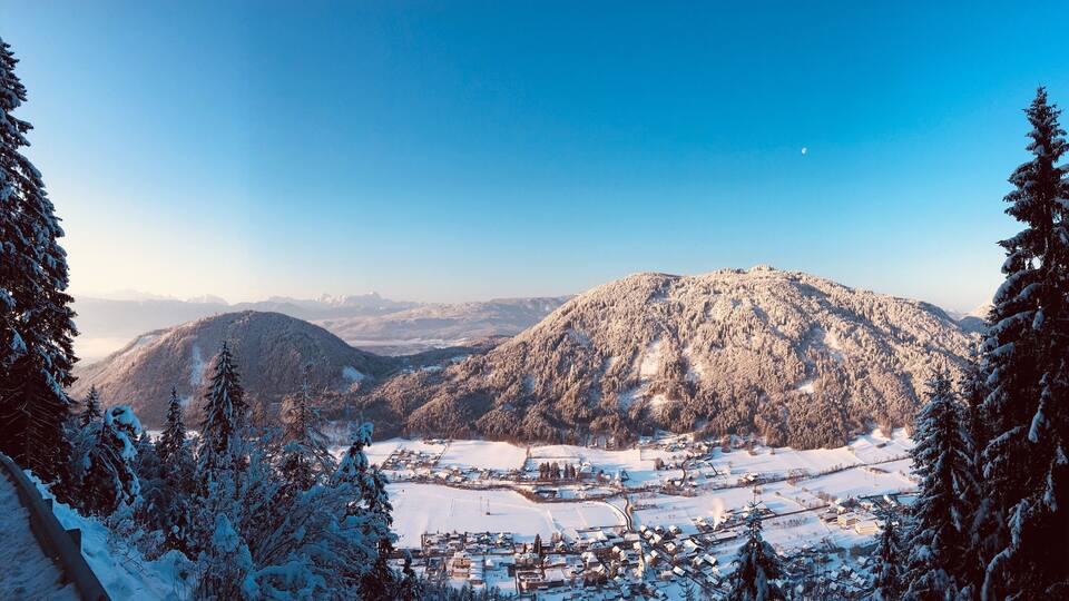 A snow-covered mountain range with a small village at its base.