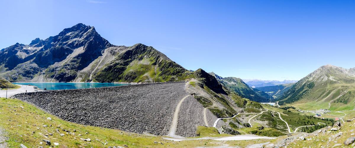 A mountain landscape with a reservoir, roads, and a small settlement.