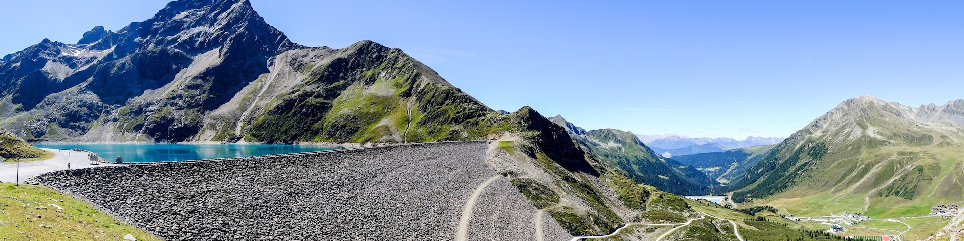 A mountain landscape with a reservoir, roads, and a small settlement.