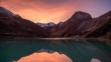 Scenic view of lake against mountain range at dusk