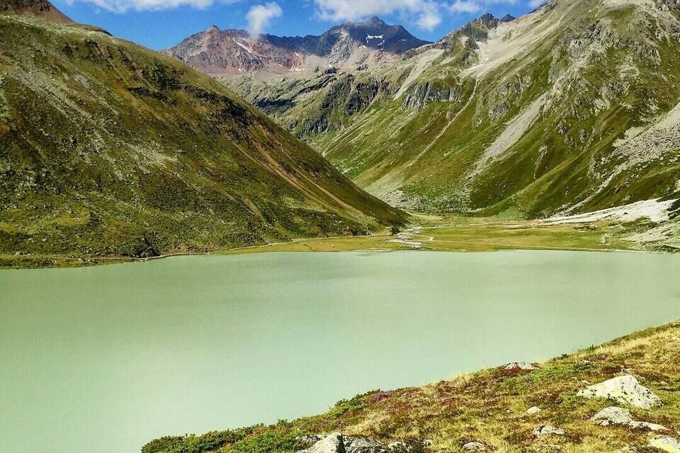 A mountain lake surrounded by rugged terrain and distant peaks.