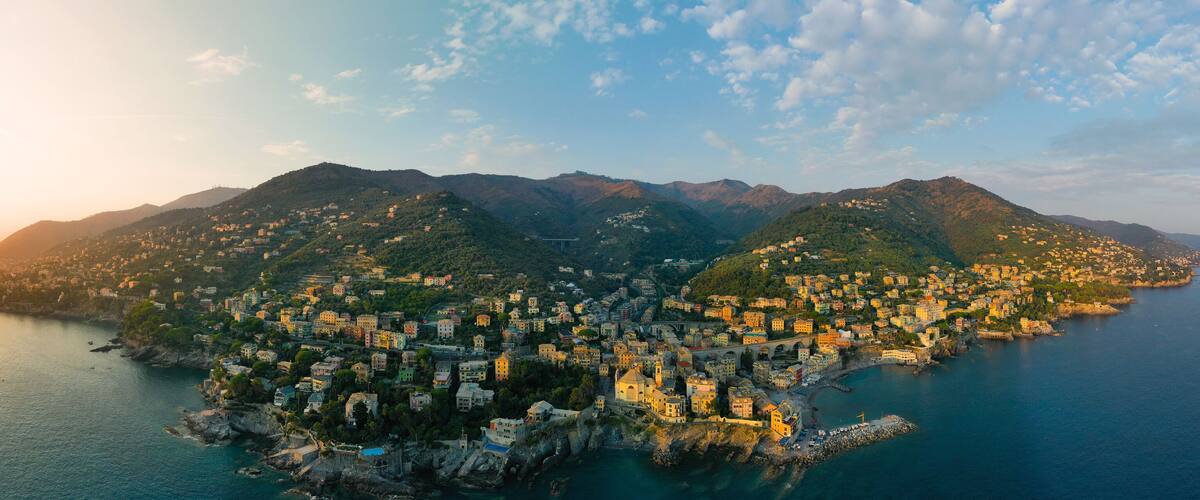 A coastal town with buildings nestled on hills overlooking the sea.