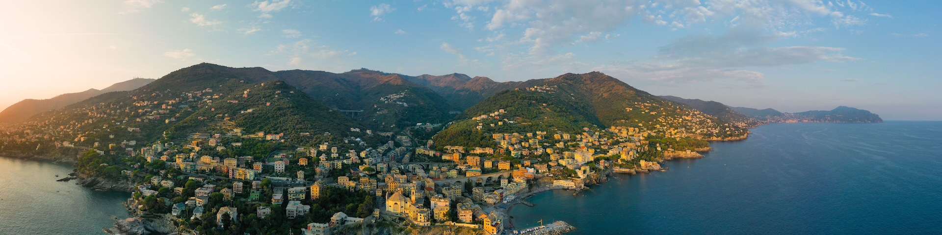 A coastal town with buildings nestled on hills overlooking the sea.