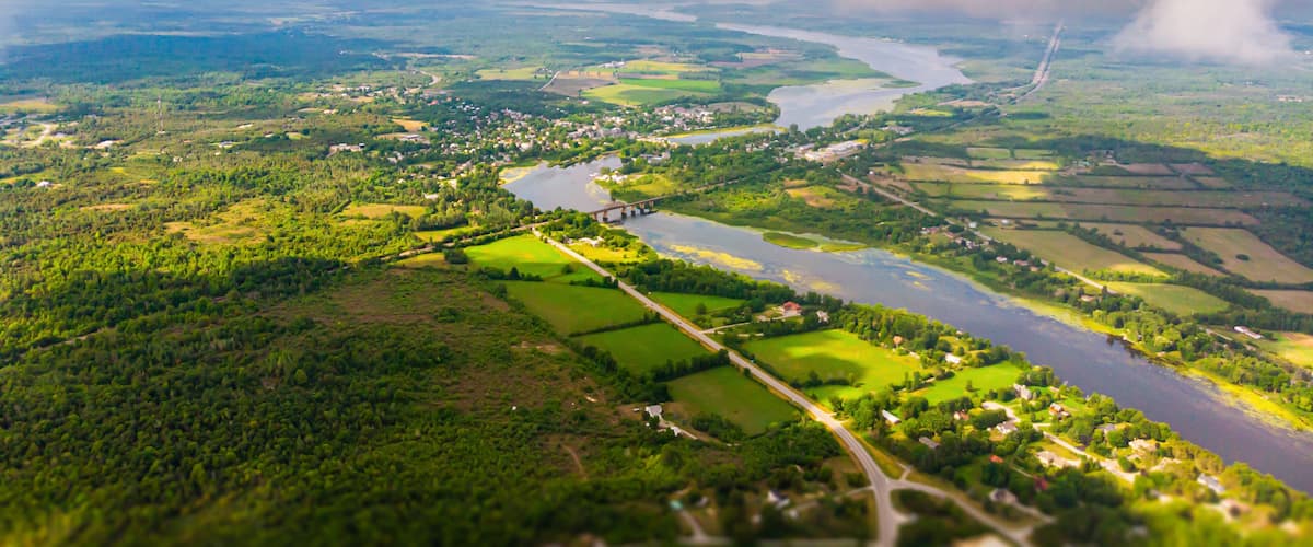 A river winding through a green landscape with fields and a small town.