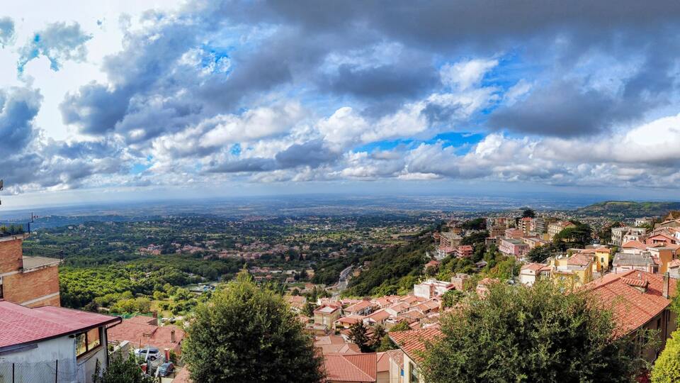 A mountainous town with terraced houses and a view of the valley below.
