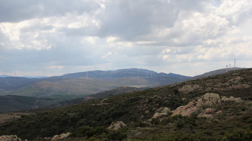 A hilly landscape with wind turbines and rocky terrain.