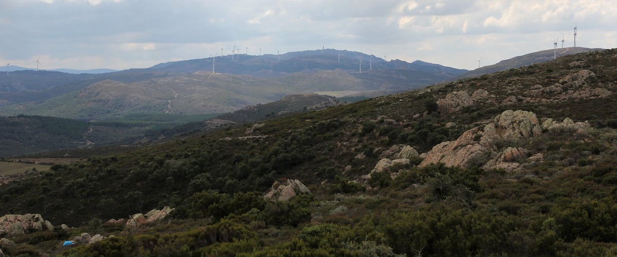 A hilly landscape with wind turbines and rocky terrain.