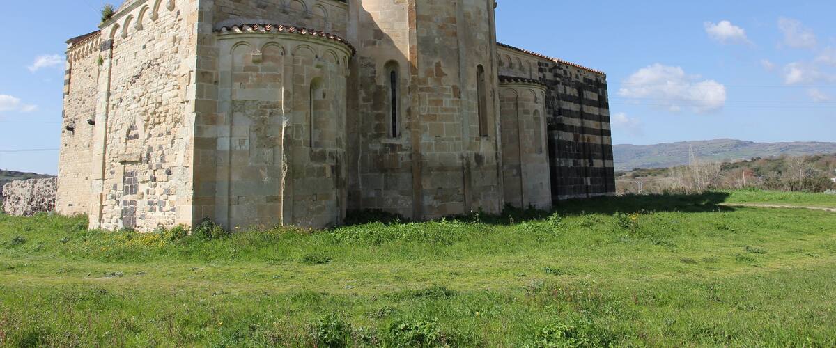 Un antiguo edificio de piedra con ventanas de arco y una torre de campanas.