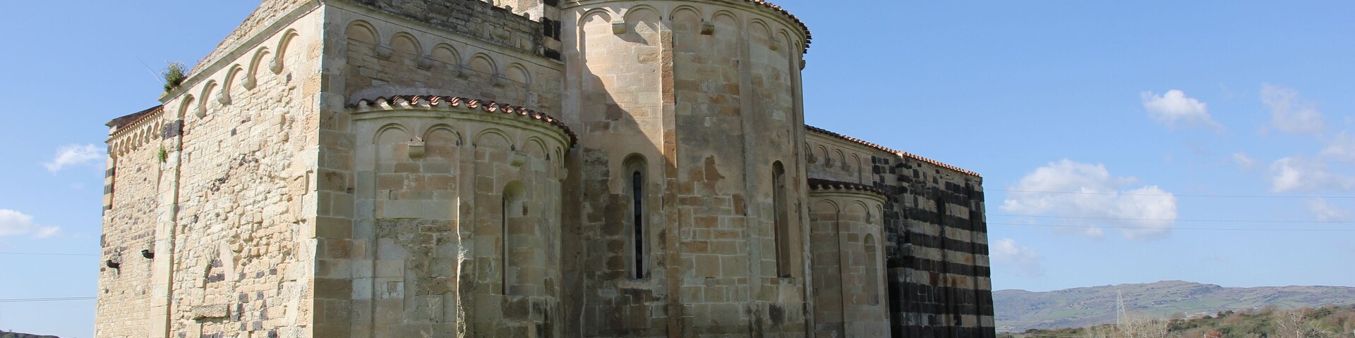 Un antiguo edificio de piedra con ventanas de arco y una torre de campanas.