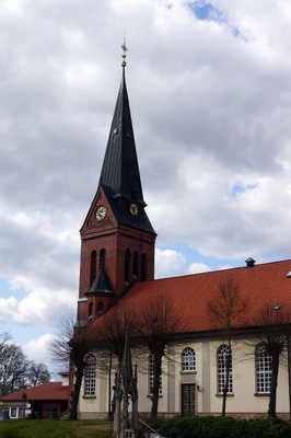 En kyrka med ett högt torn och en klocka.