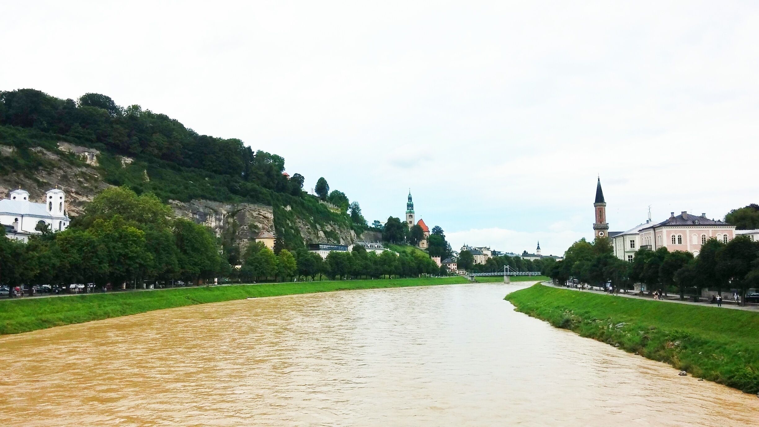 A river flowing through a city with historic buildings and a prominent tower.