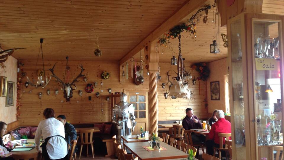 A wooden interior with antlers and animal heads on the walls, tables, and chairs.