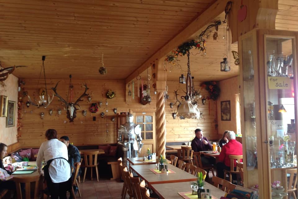 Ein rustikales Interieur mit Geweihen und Tierköpfen an den Wänden, Tischen und Stühlen.
