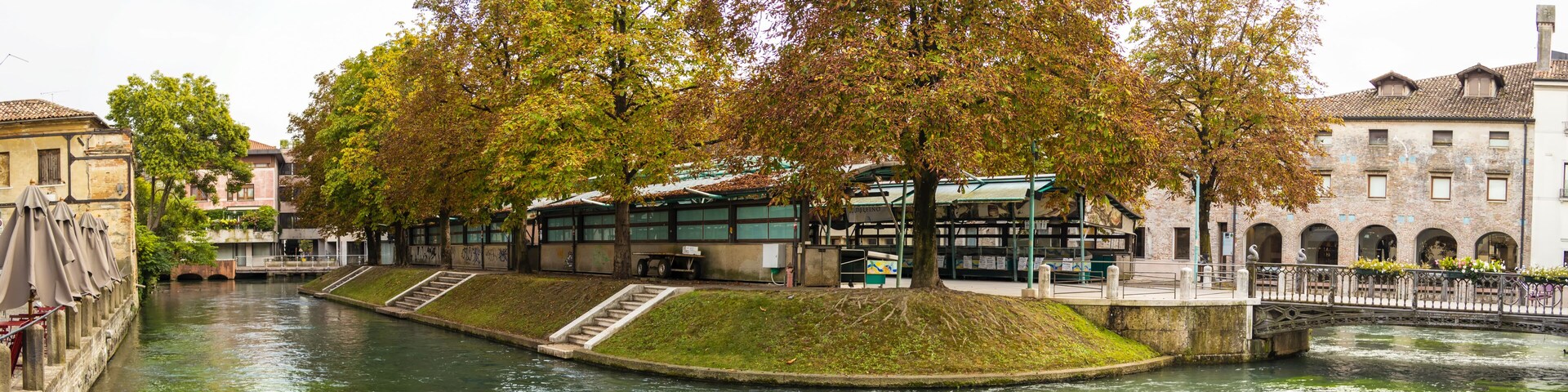 A river with a bridge, trees, and buildings along the banks.