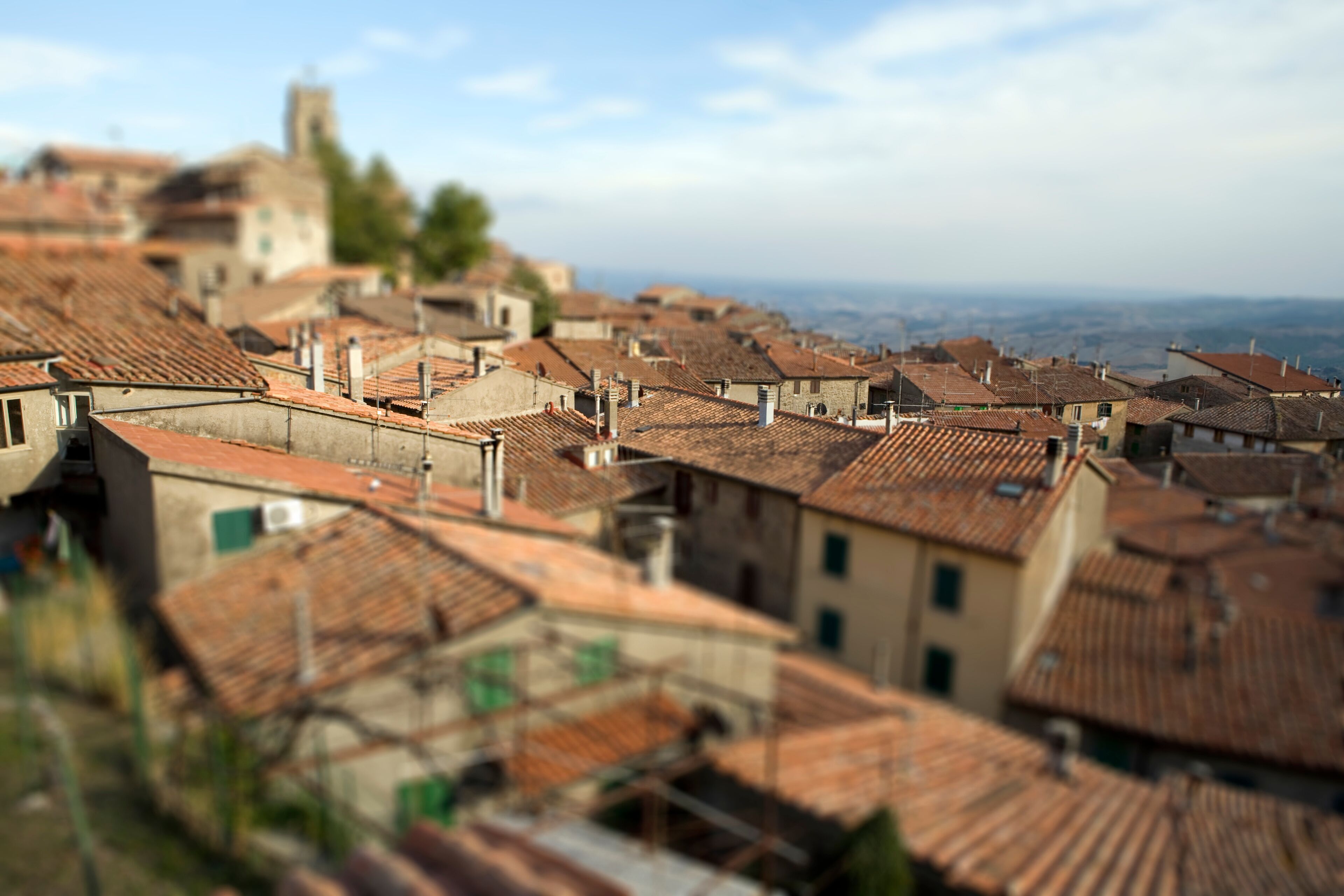 A town with terracotta-roofed buildings and a distant church.