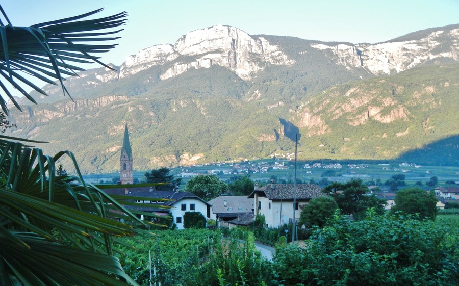 Un pueblo con una iglesia y una montaña al fondo.