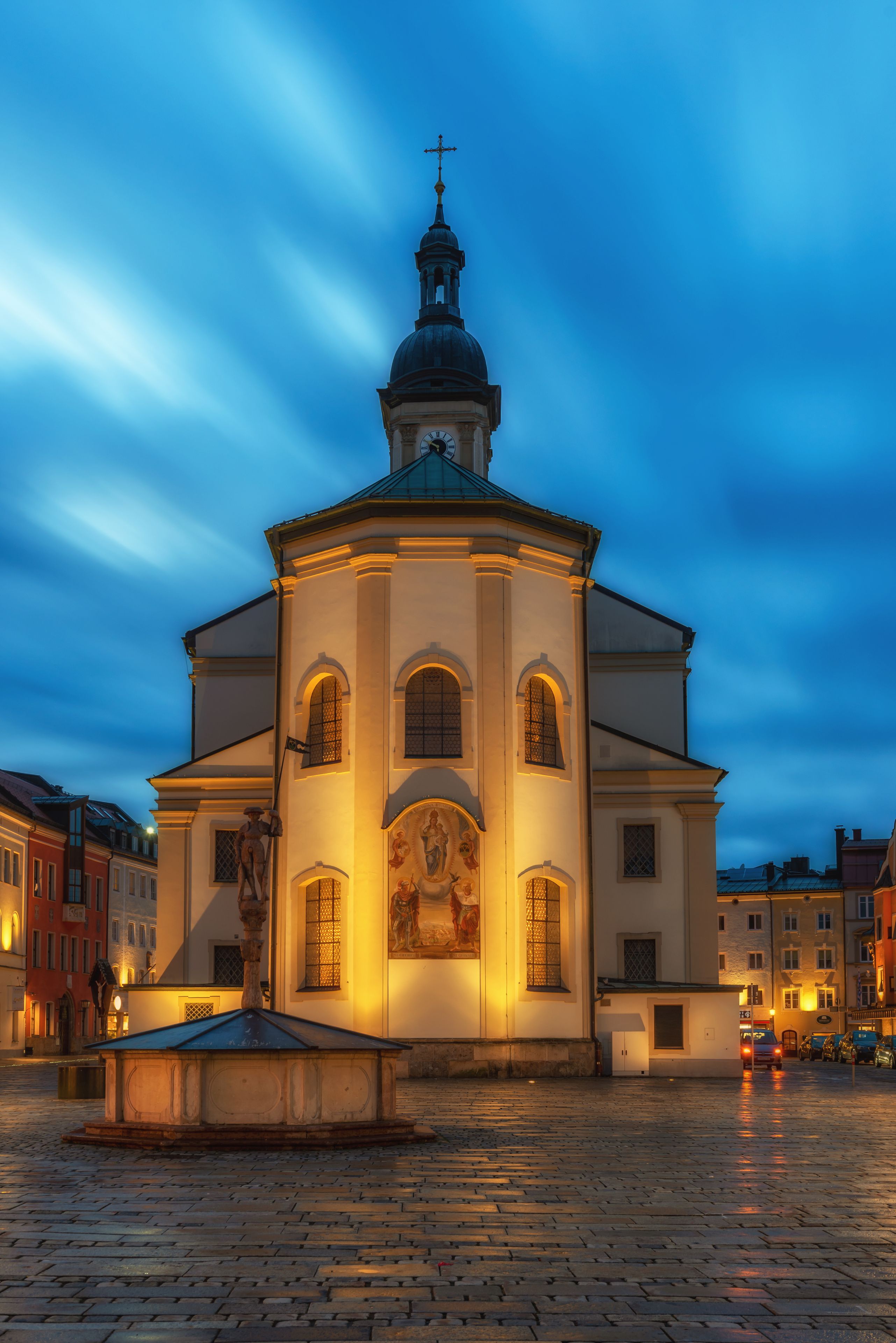 A church with a dome and cross, surrounded by cobblestone streets and buildings.