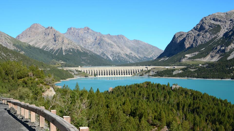 A dam with a reservoir in a mountainous landscape.