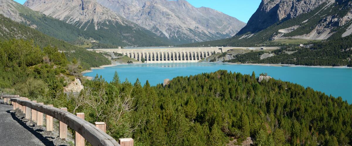 A dam with a reservoir in a mountainous landscape.
