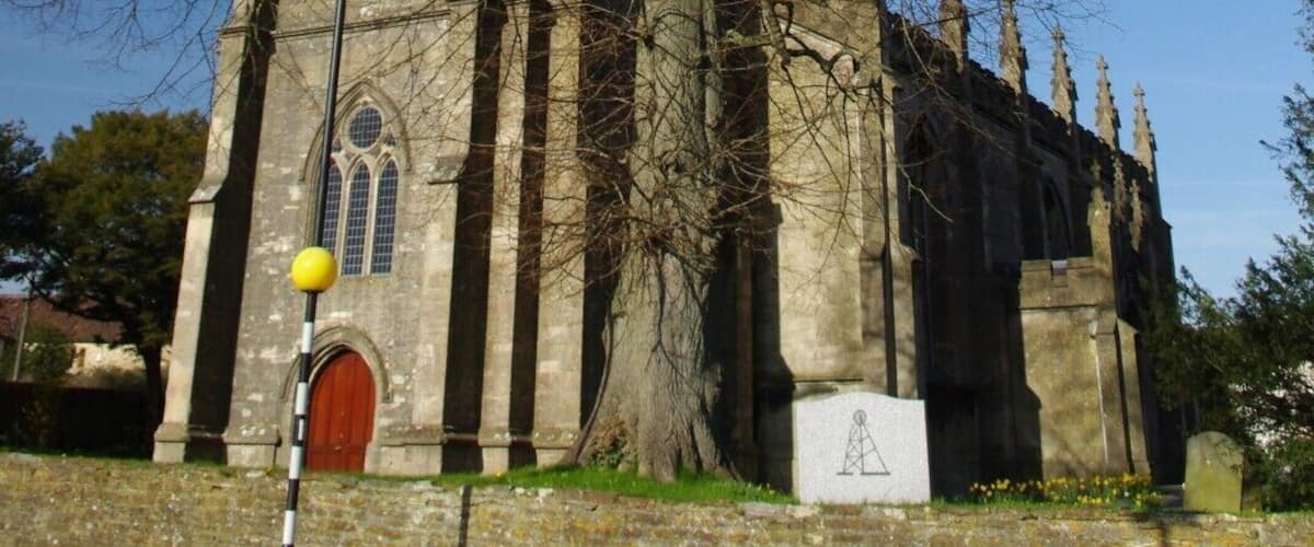 A historic church with a large tree in front.