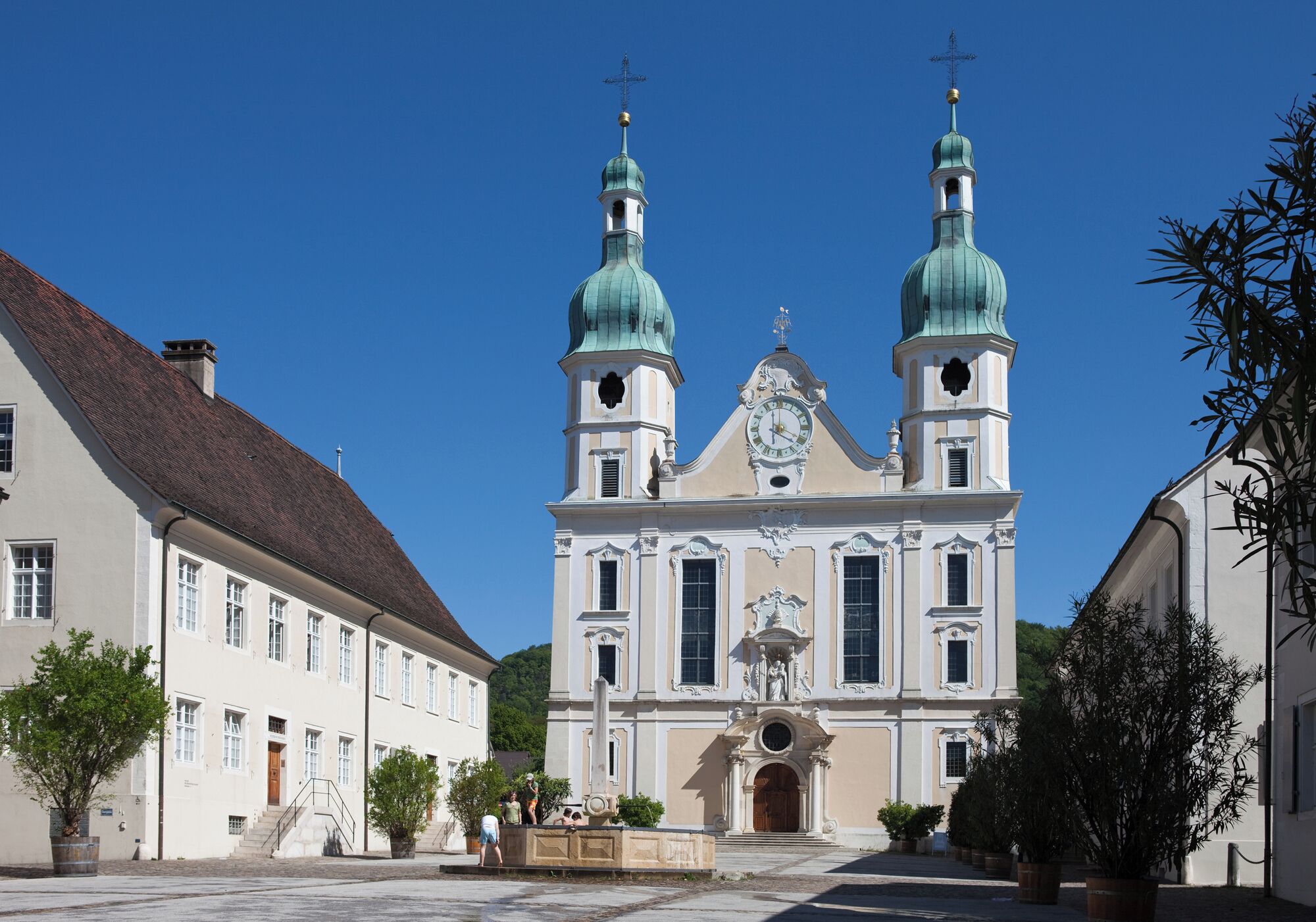 A historic church with two green domes and a clock tower.