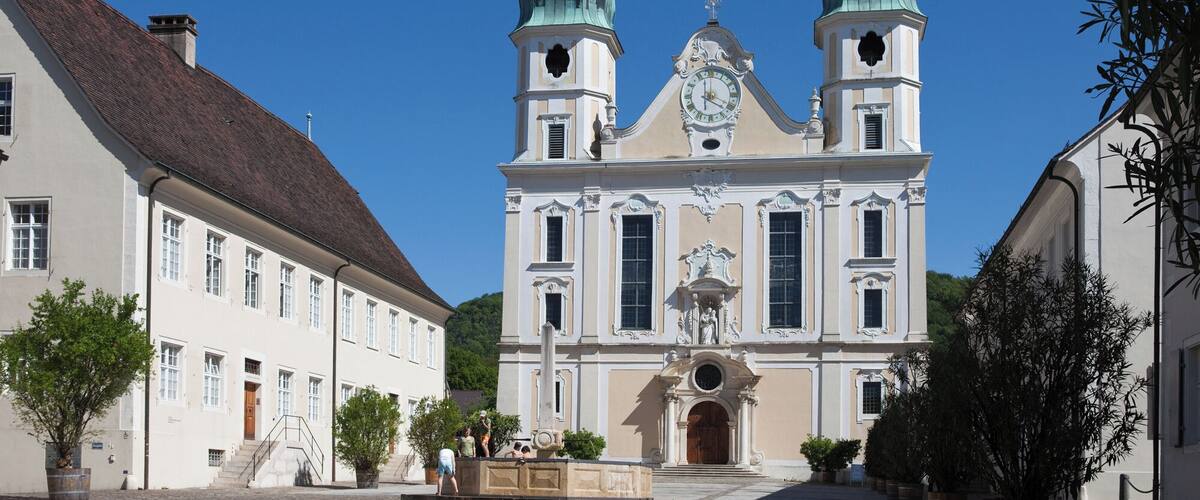 A historic church with two green domes and a clock tower.