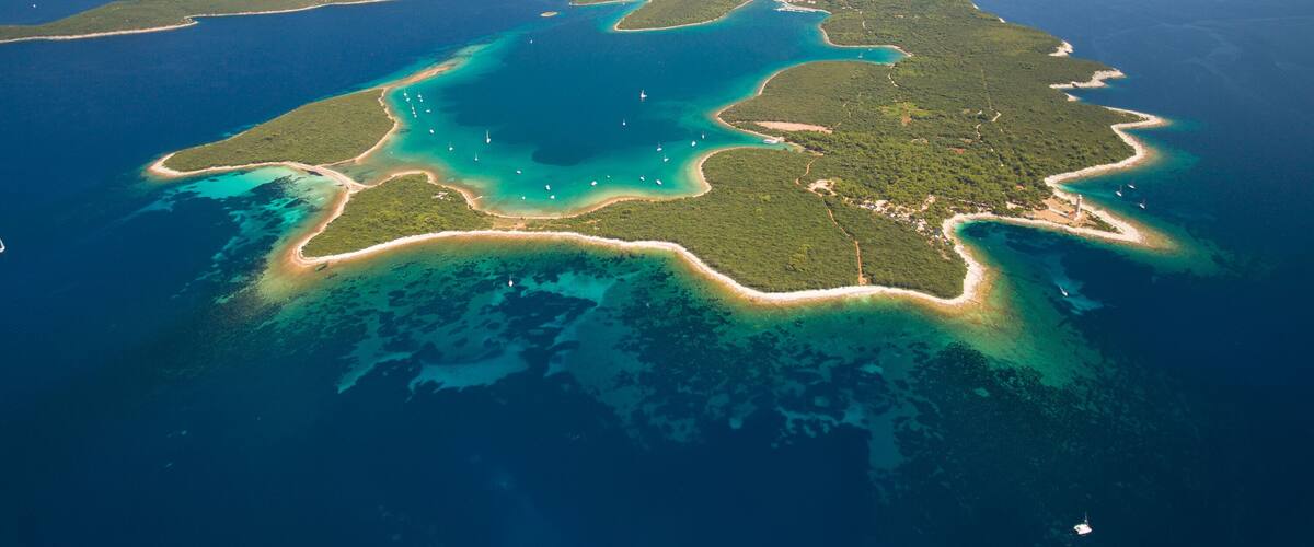Vista aérea de una región costera con una gran bahía, varias islas y aguas azules cristalinas.