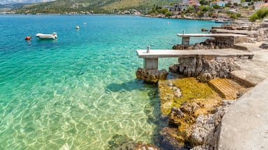 Un pueblo costero con aguas turquesas cristalinas, barcos y costas rocosas.