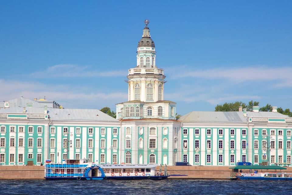 Un edificio storico con una torre imponente e un fiume sullo sfondo.