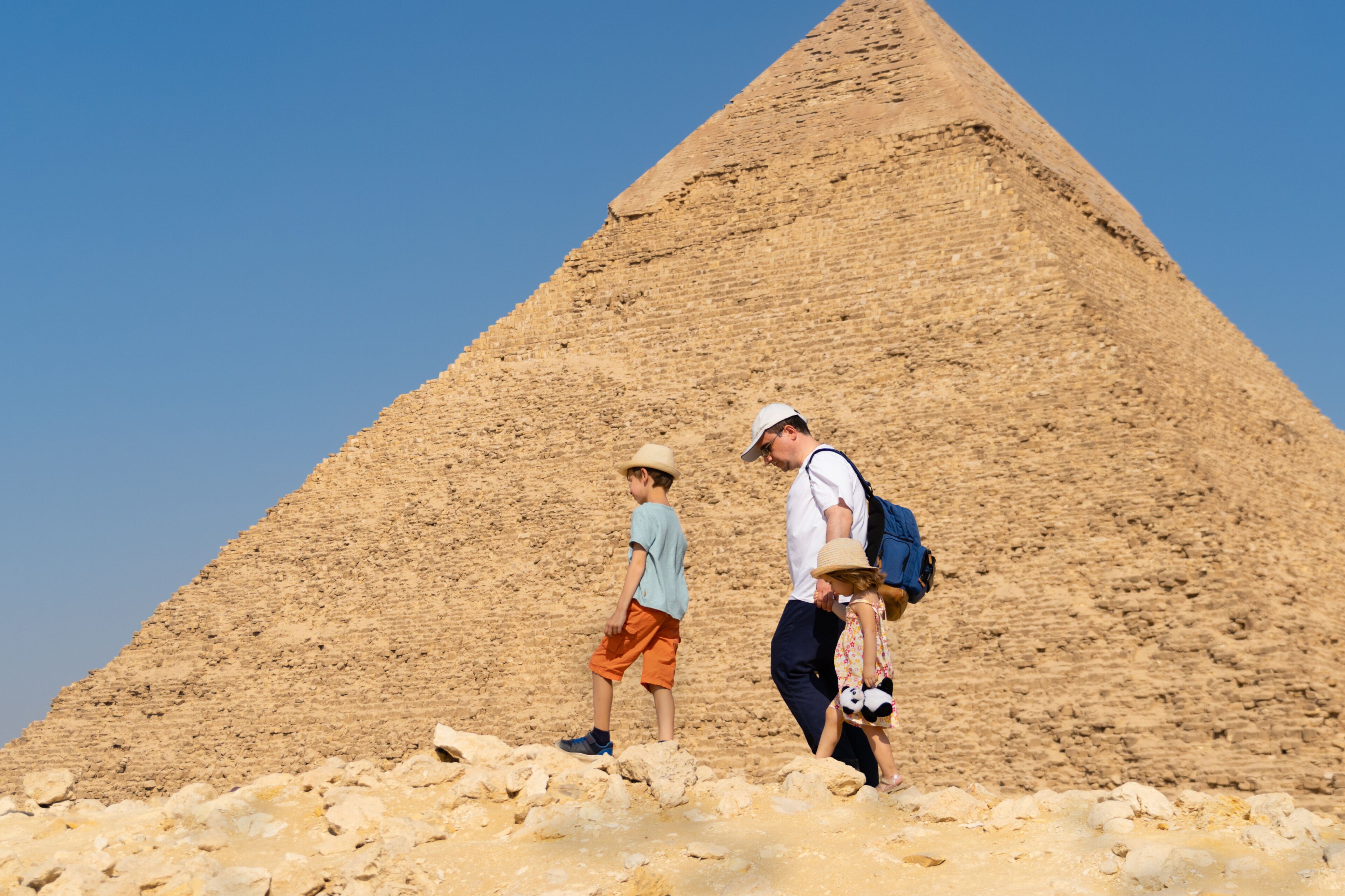 Father and children walk in front of the Chephren pyramid on the Giza plateau