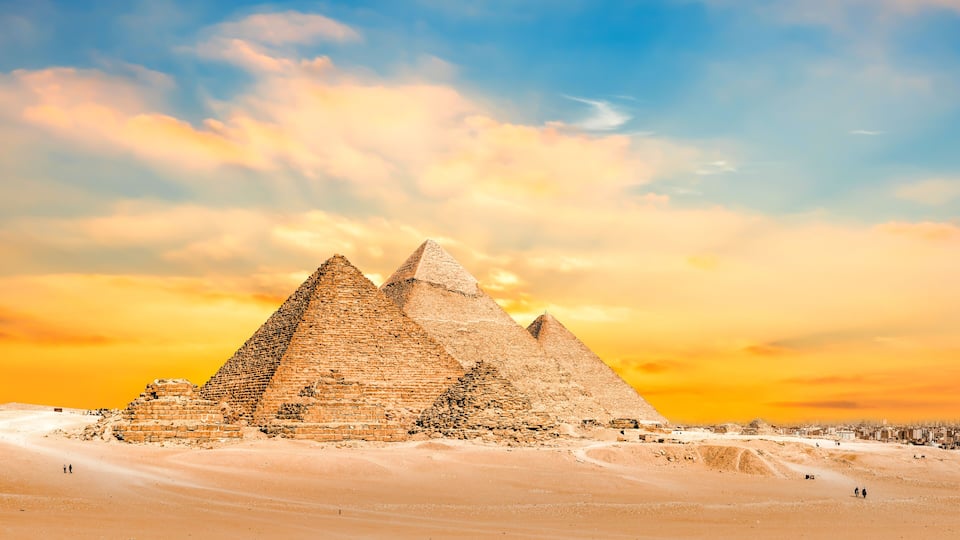 The Great Pyramid of Giza with the Sphinx in the background, set against a desert landscape.
