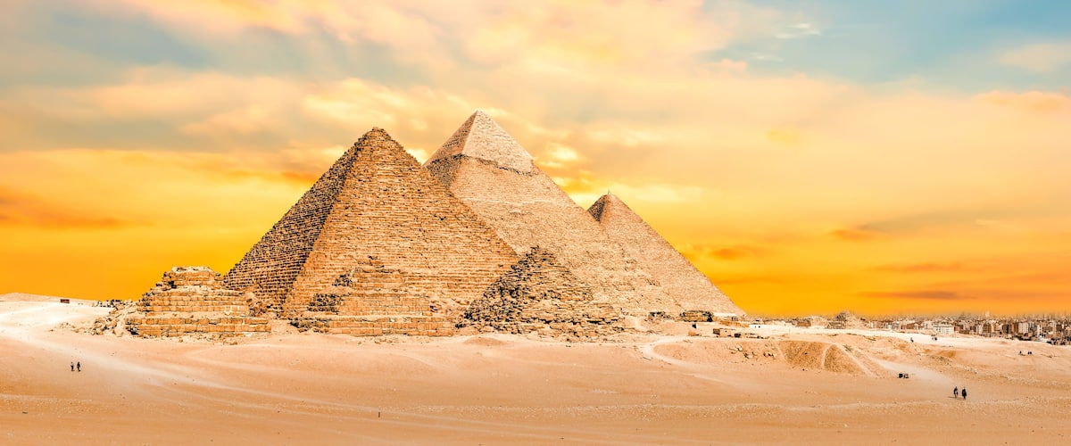 The Great Pyramid of Giza with the Sphinx in the background, set against a desert landscape.