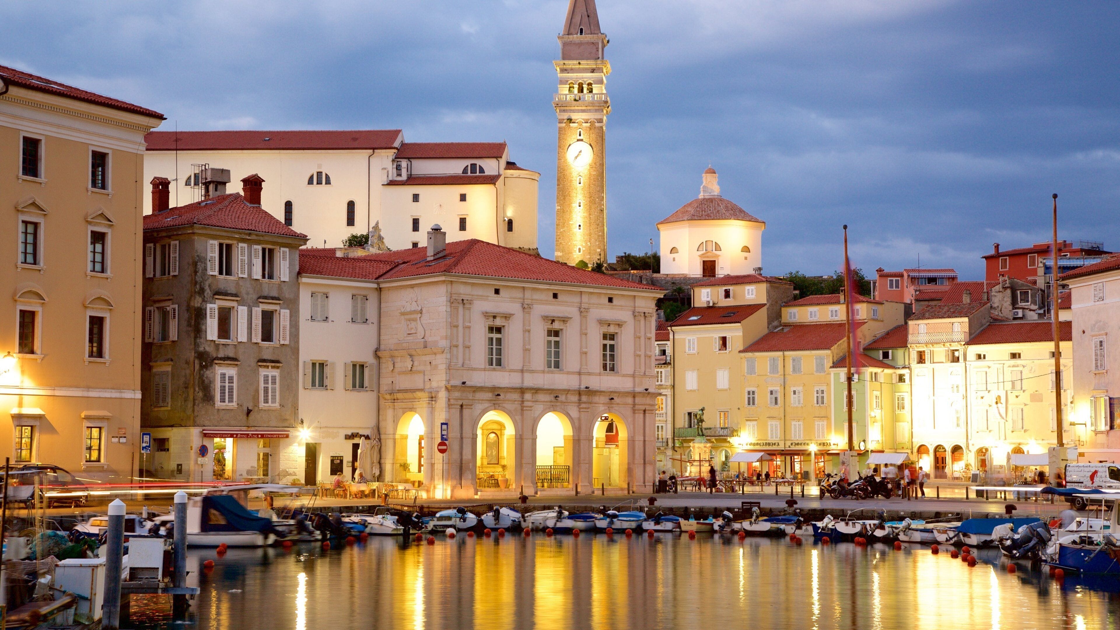 A waterfront with historic buildings, a prominent clock tower, and a mosque.
