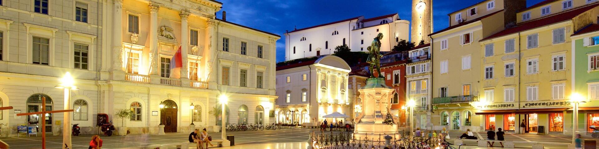 Piran mostrando piazza e paesaggio notturno cosi come un grande gruppo di persone