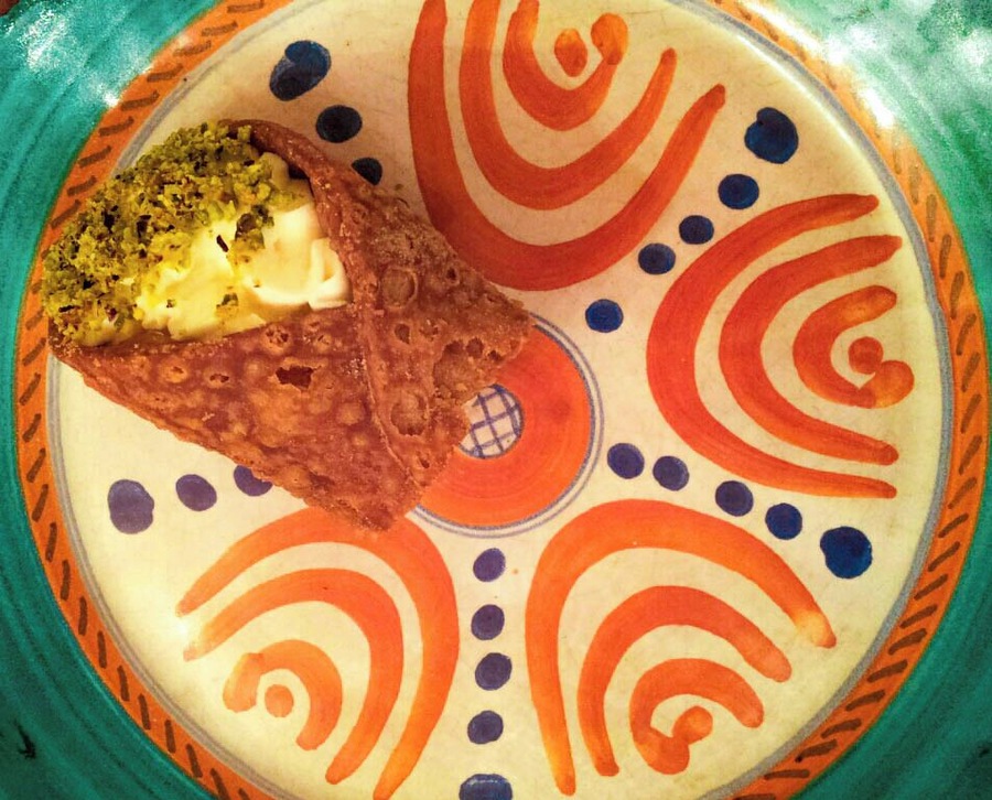 #Lunchtime
The Sicilian cannolo is one of the most famous Italian sweets in the world. Contrary to what most people believe, these delicious ricotta-cream filled wafers have been around for a long, long time. During his time spent in Sicily as a Roman queastor, Cicero fell in love with a predecessor of the modern cannolo. He described the dessert as a tube stuffed with a sweet, milk-based filling.
According to some accounts, however, the creation of modern cannoli came as a result of the Arabs who once controlled Sicily. This satisfying sweet was likely created inside a Muslim harem in the city of Kalt El Nissa, modern-day Caltanissetta. In this harem, the women spent their time preparing this delicacy.
In fact, it may very well have been on of these women who modified a preexisting Arab dessert made with ricotta, almonds and honey to fit Cicero’s description. In doing so, she created what is now known throughout the world as Sicilian cannoli.
