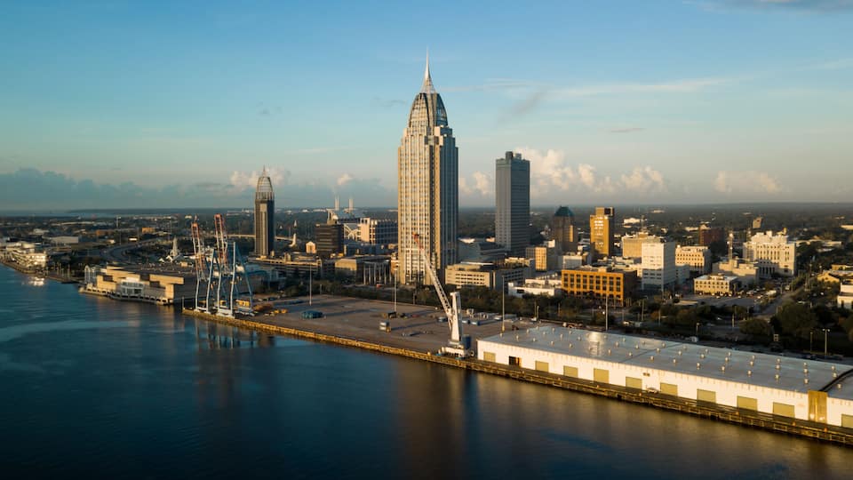 A city skyline with a prominent skyscraper, a waterfront, and a bridge.