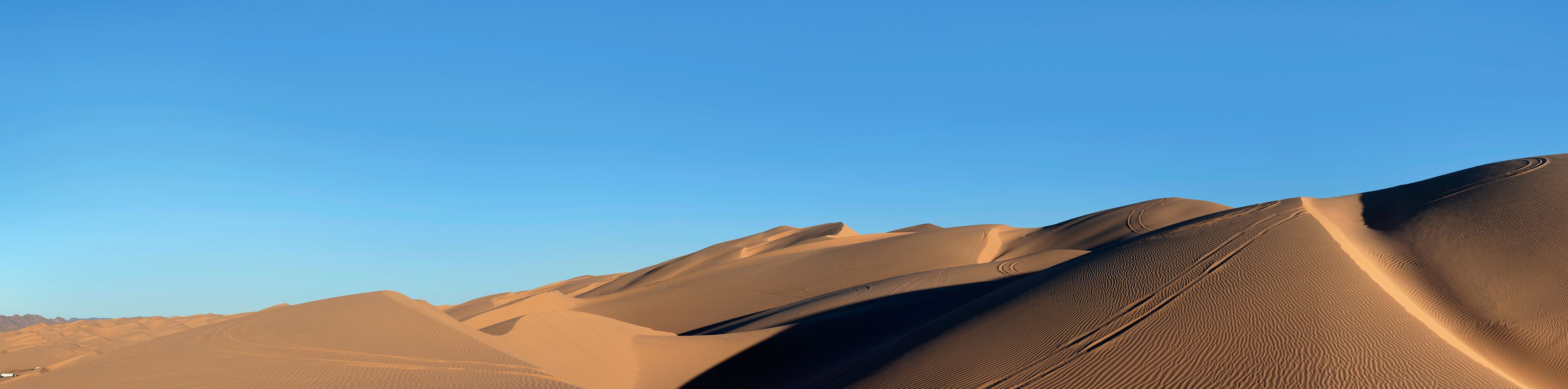 Sand dunes under a clear sky.