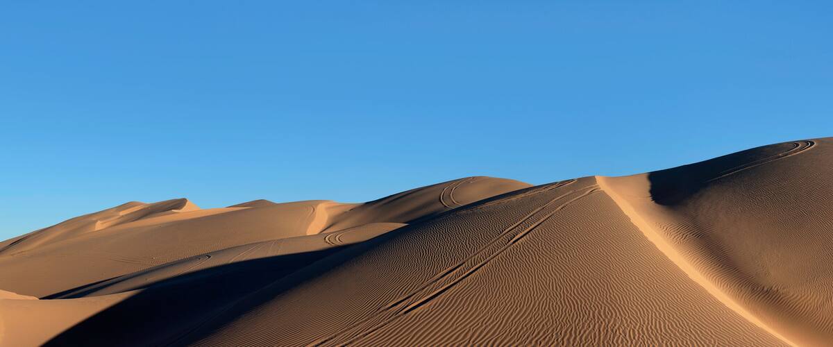 Sand dunes under a clear sky.
