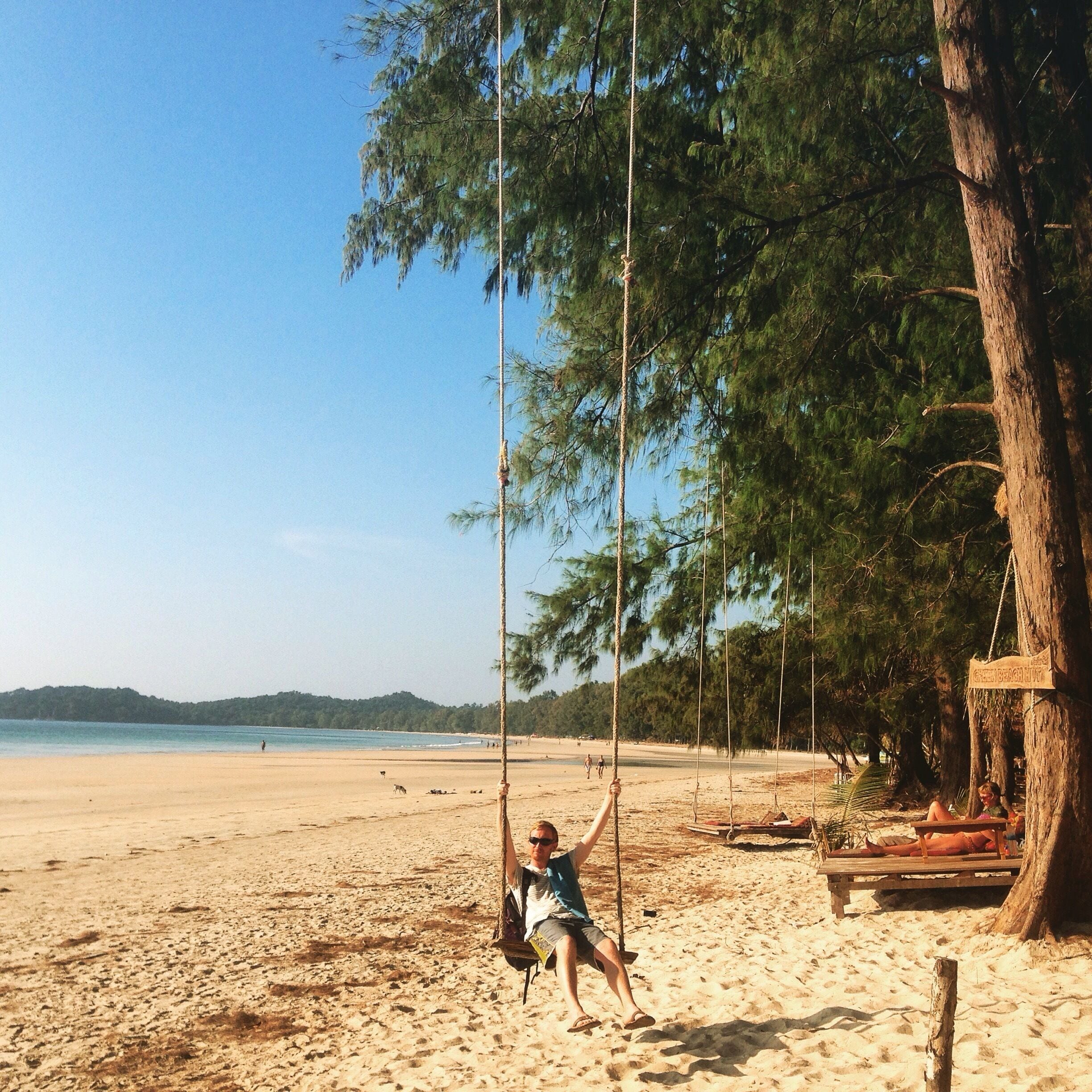 A beach with a swing set and a wooden structure.