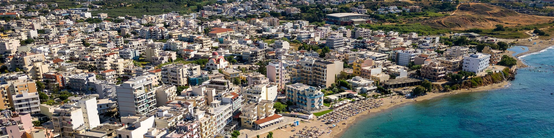 Aerial view of a busy beach in the popular resort town of Nea Chora in Chania, Crete (Greece)