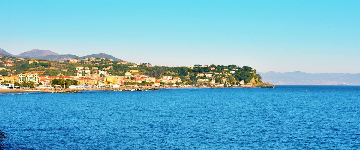 A coastal town with buildings on a hillside overlooking the sea.