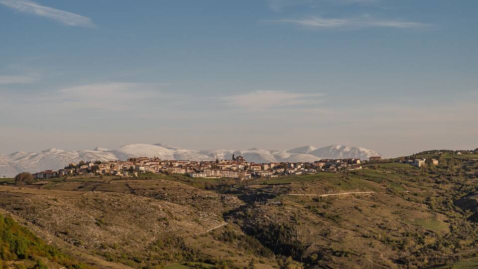 A mountainous landscape with a village nestled among the hills.