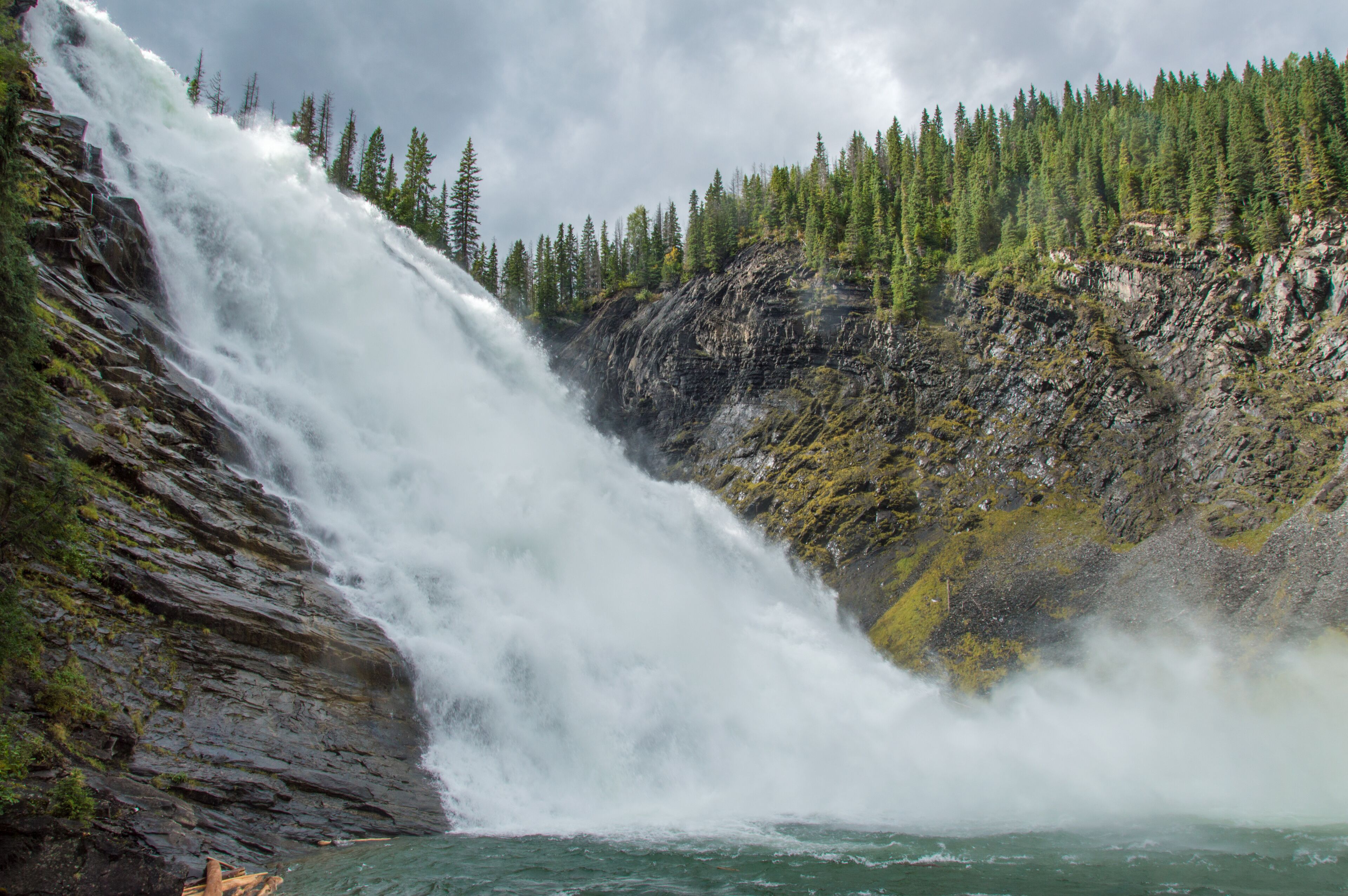 Looking up towards a fast flowing waterfall in the forest during a hike