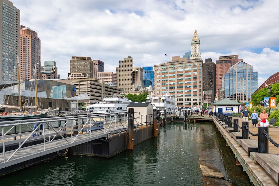 A cityscape with a river, a bridge, and a historic clock tower.