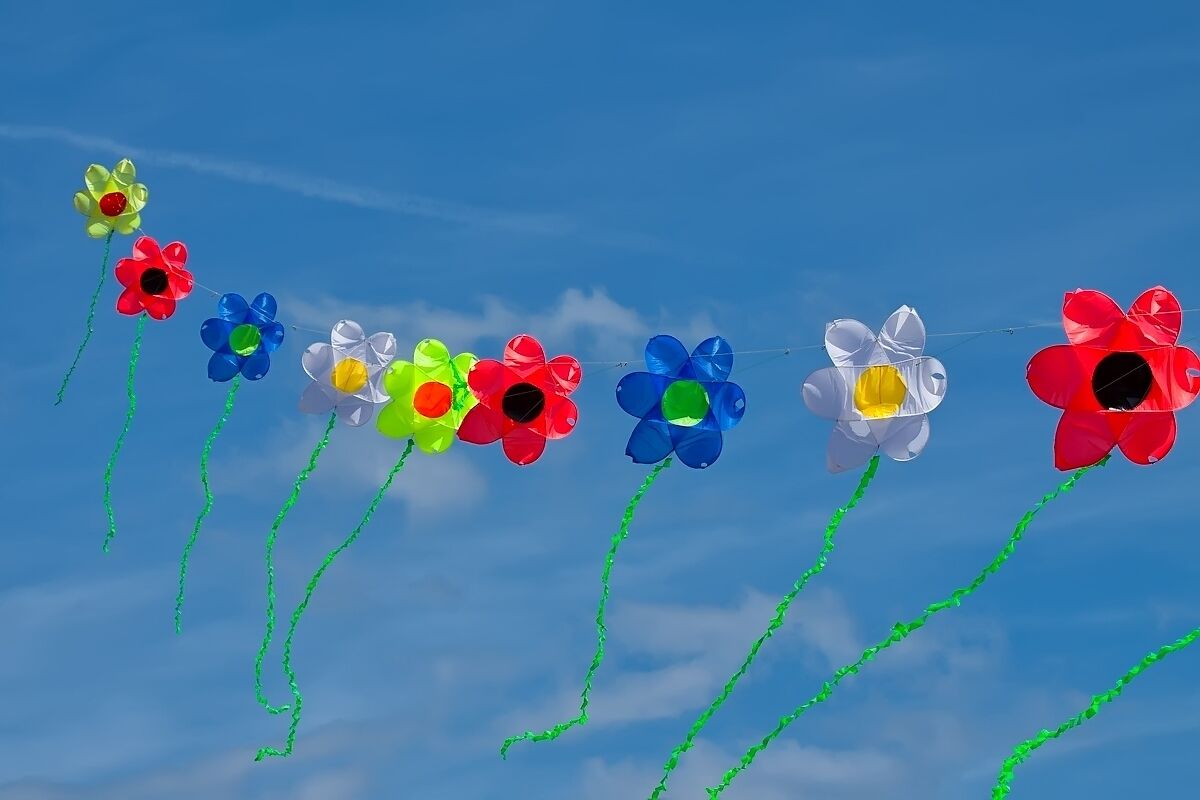 A string of colorful pinwheels against a clear blue sky.