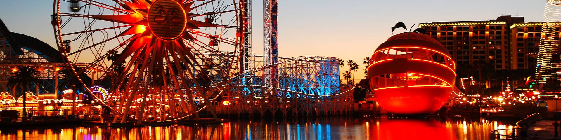 The bright colorful lights of Disney's California Adventure amusement park is reflected in the lake